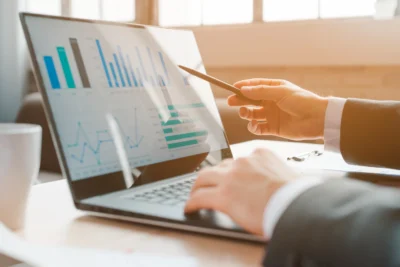 Análise de gráficos sobre Inteligência Artificial e previsões de mercado em um laptop, com foco na interpretação de dados financeiros.