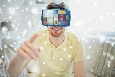 Homem sorridente usando óculos de realidade aumentada em um ambiente aconchegante, interagindo com conteúdos digitais.