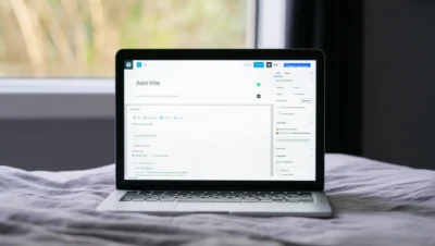 Imagem de um laptop aberto sobre uma cama, exibindo uma tela de edição com a opção para adicionar um título, perfeita para otimização de title tags.