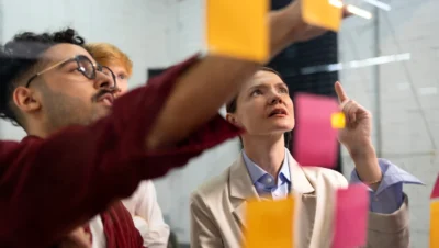 Imagem de uma equipe discutindo estratégias de marketing, destacando a comparação entre Inbound e Outbound e como escolher a melhor estratégia para o negócio.
