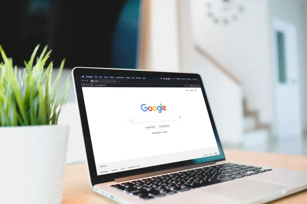 Imagem de um laptop mostrando a página inicial do Google, representando a comparação entre Google Discover e Google News, ideal para otimização em SEO.