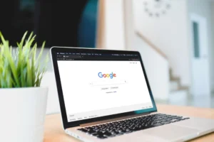 Imagem de um laptop mostrando a página inicial do Google, representando a comparação entre Google Discover e Google News, ideal para otimização em SEO.