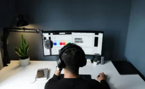 Pessoa assistindo a um webinar sobre as últimas tendências e inovações do setor, com foco na modernidade e tecnologia, usando headset e computador dual screen.