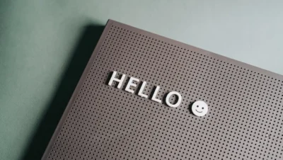 Quadro de avisos com a palavra 'HELLO' e um sorriso, simbolizando o uso de gamificação no aprendizado de idiomas com elementos visuais divertidos